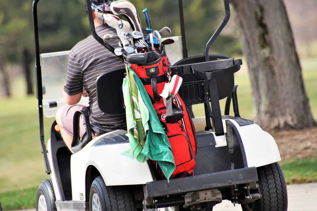 golf-course-golf-driving-closeup-golfer-from-behind-golf-clubs-golf-cart-playing-sports_t20_9errrv