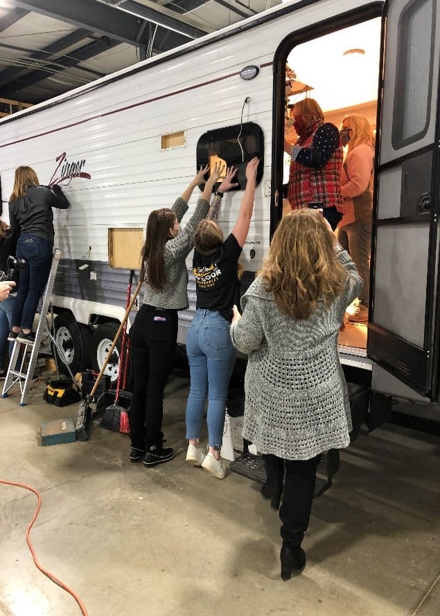 A group of women participating in an RV renovation.