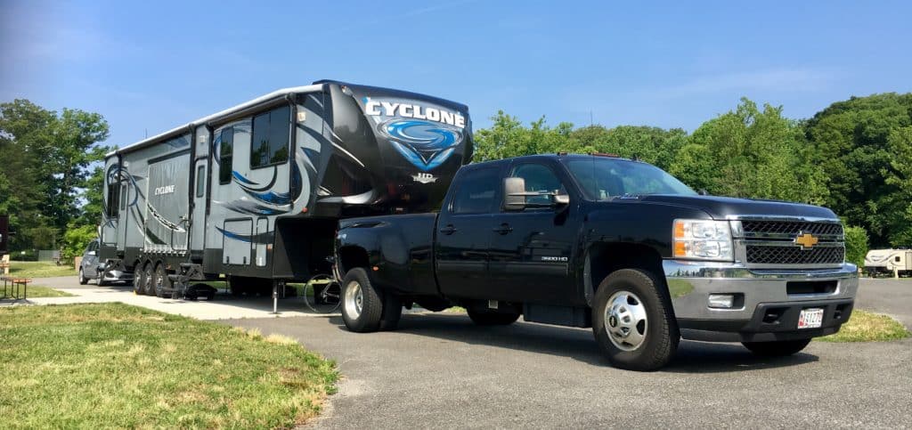 A Chevy truck pulling a large Cyclone RV