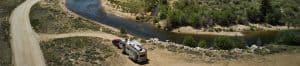 panoramic shot of an RV next to a river