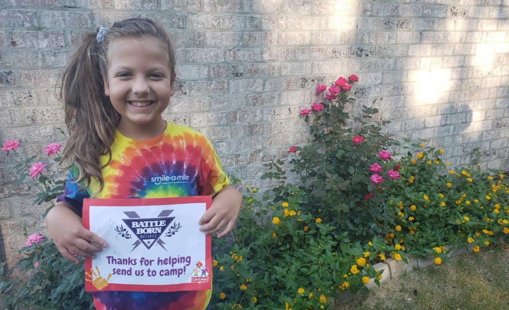 A Care Camps participant holding up a thank you sign.