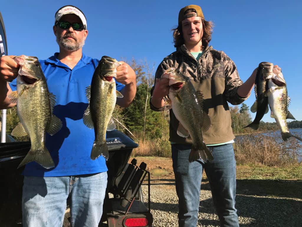 Neil Hester (left) and Austin Hester (right) holding fish in each hand in December 2020, at Tired Creek Lake, Georgia.