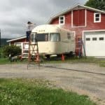Crystal power washing her vintage camper Zola after purchase.