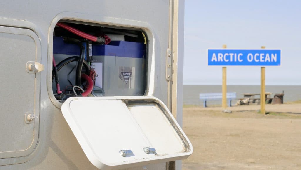 battery in rv compartment near a "Arctic Ocean" sign
