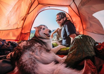 Kelly Lund and Loki in a tent. 
