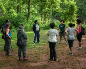 A group of Outdoor Afro hikers in a opening circle getting ready for a hike.