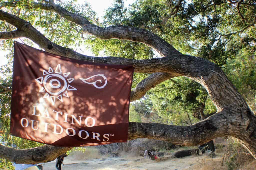 The Latino Outdoors flag attached to a tree.