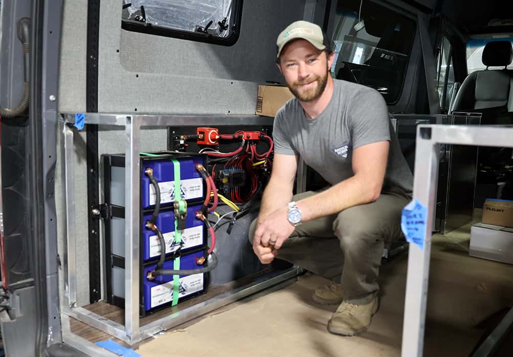 KP Pawley posing with his Battle Born Batteries inside of his rig