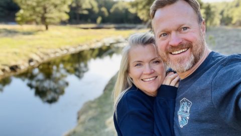 Marc and Tricia Leach smiling next to a body of water