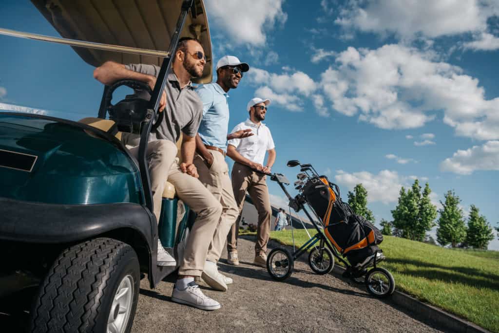 group of men riding electric golf cart