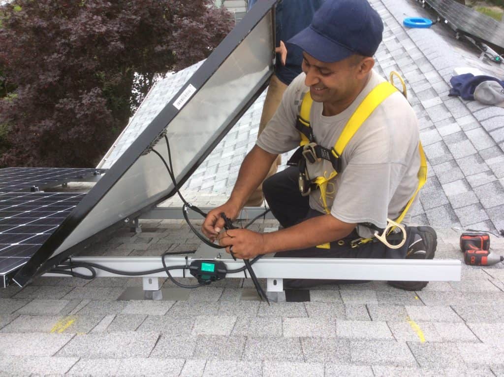 man inspecting solar panel wiring