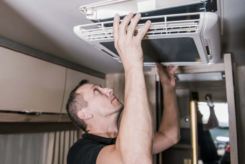 man cleaning rv ac unit