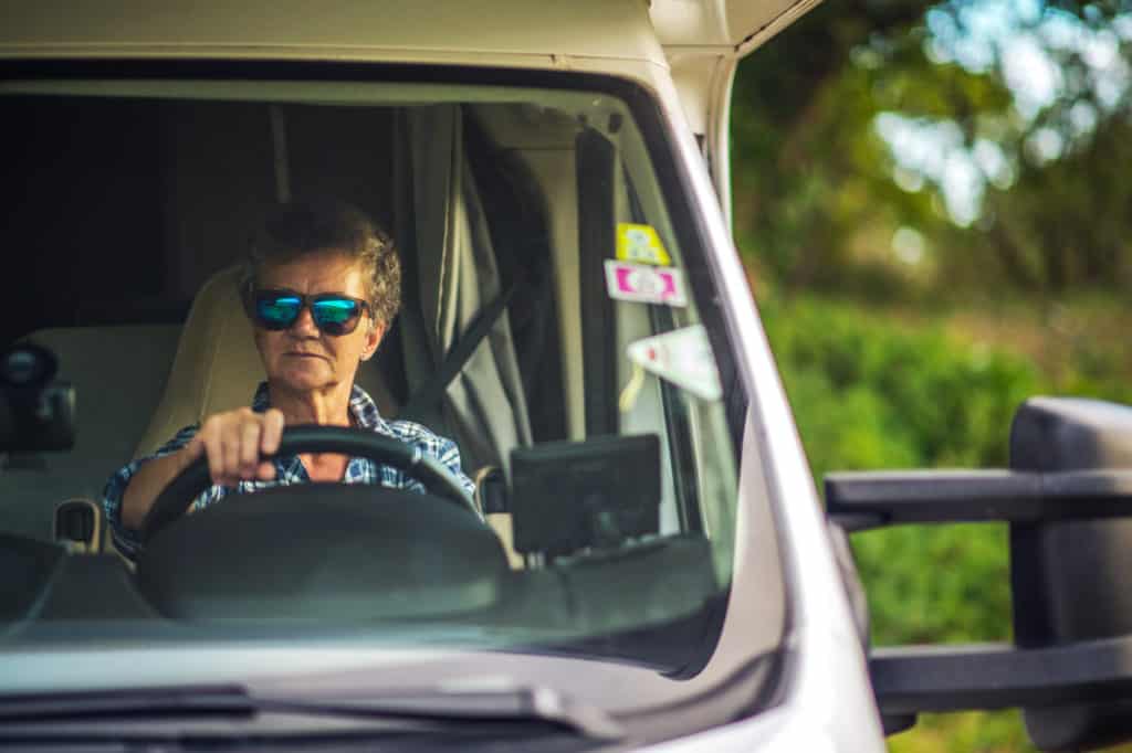 woman wearing sunglasses driving a motorized rv