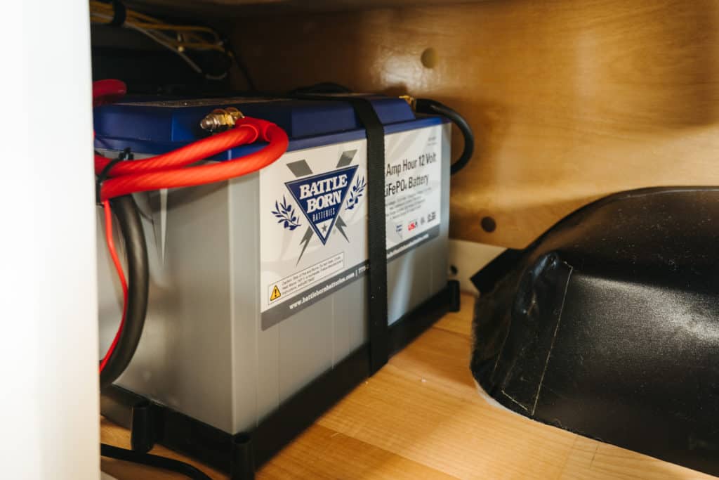A 100Ah 12V Battle Born Battery strapped into a cabinet