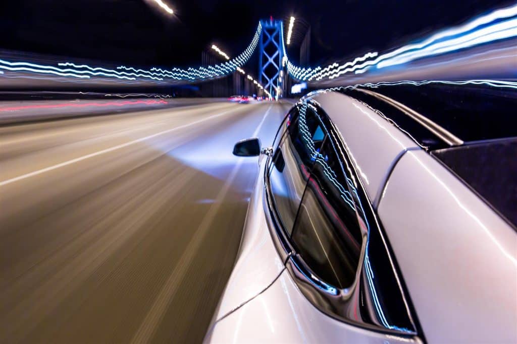 Shot of a car driving on a lit up bridge