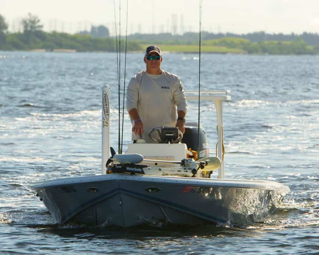 John McDaniel driving a fishing boat on a lake