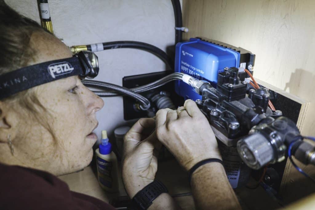 Woman wearing a headlamp installing solar components