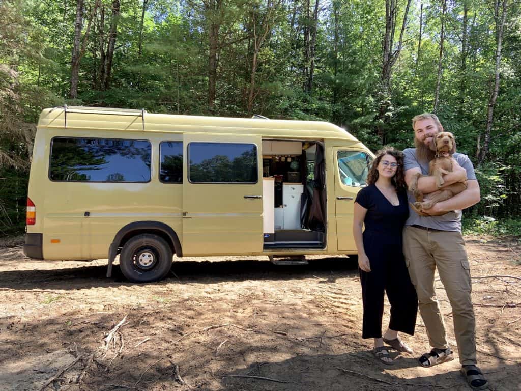 Davis and Logan posed in front of their yellow van while David holds their dog
