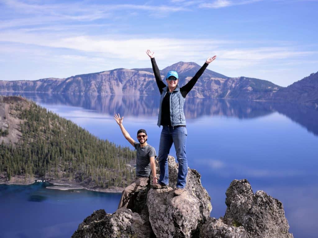 mortons on the move at crater lake with their arms in the air