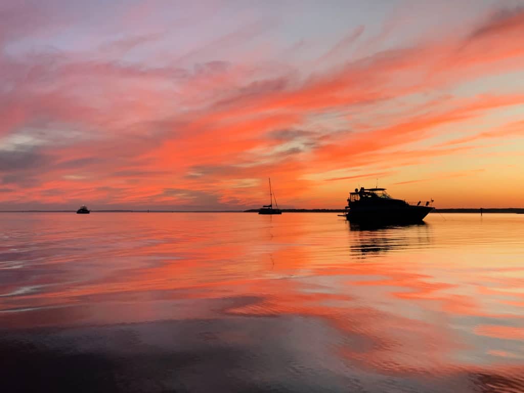Boats in the water during a colorful sunset