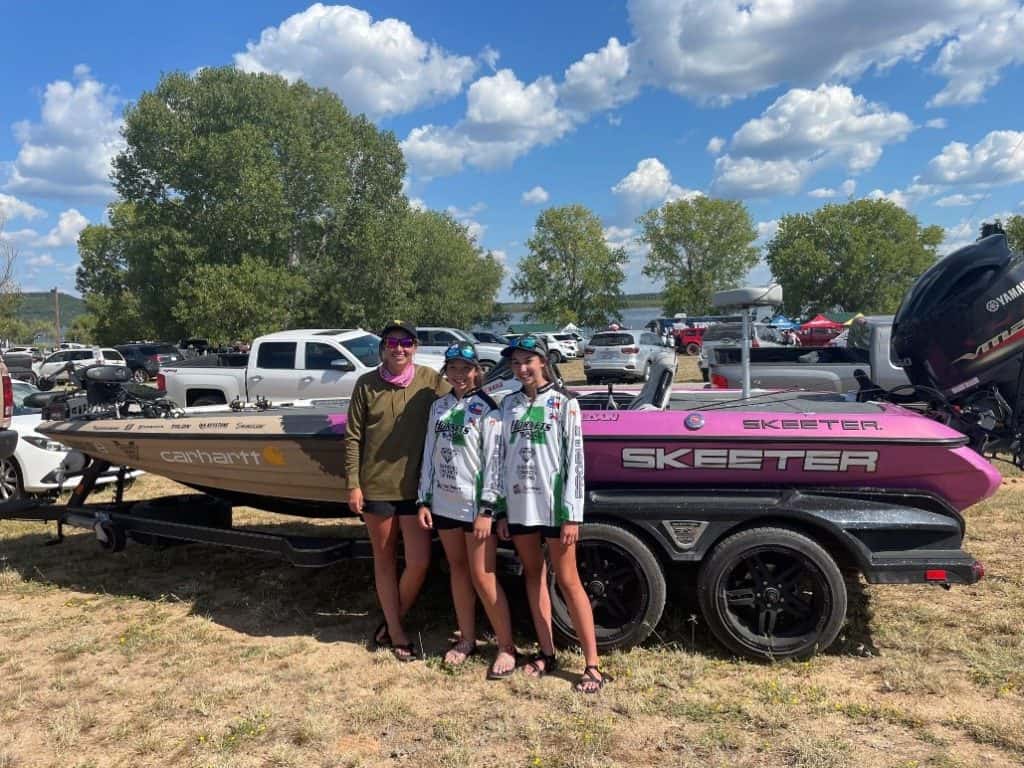 Trait Zaldain and two high school female anglers posing in front of Trait's boat.