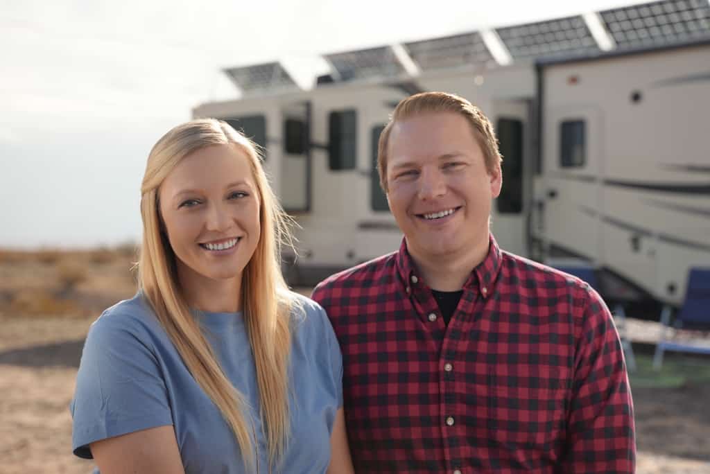 jason and rae miller of getaway couple in front of their RV with solar panels