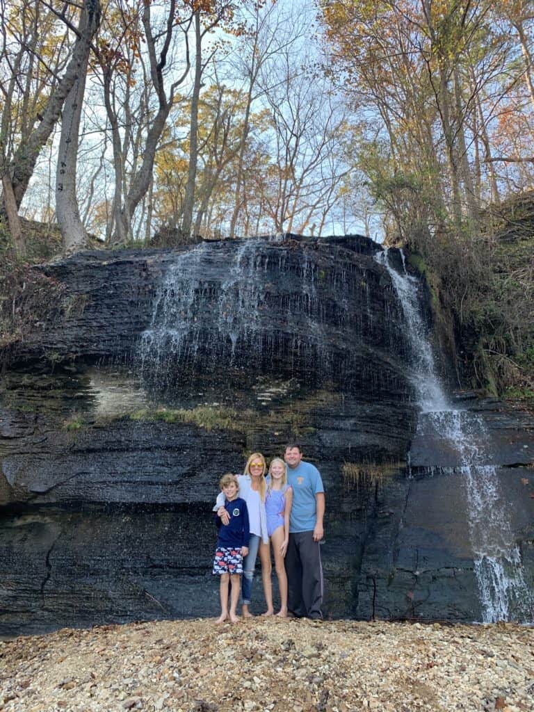 The Bowlin family embracing in front of a waterfall