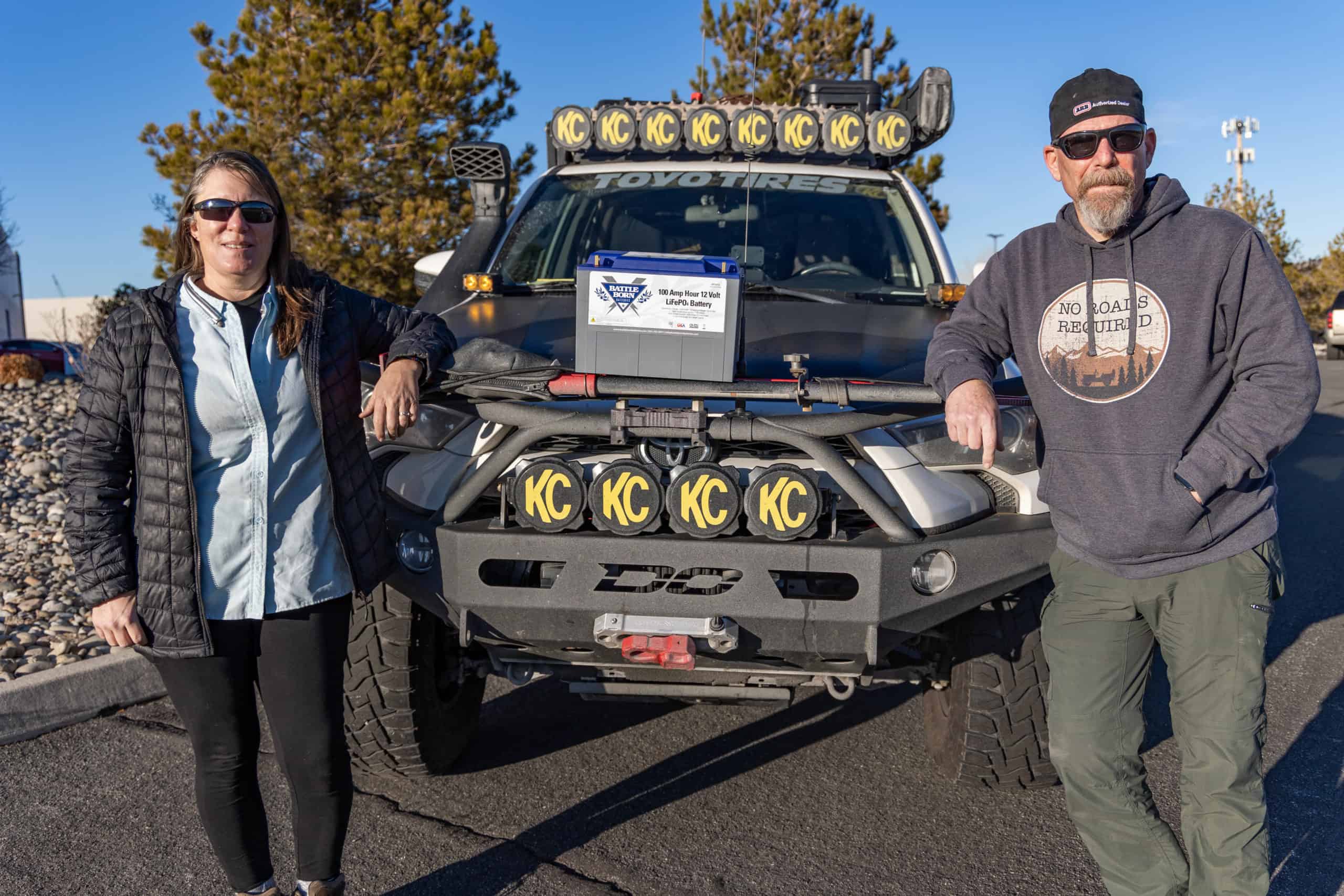 Ironhorse Overland couple standing in front of their rig