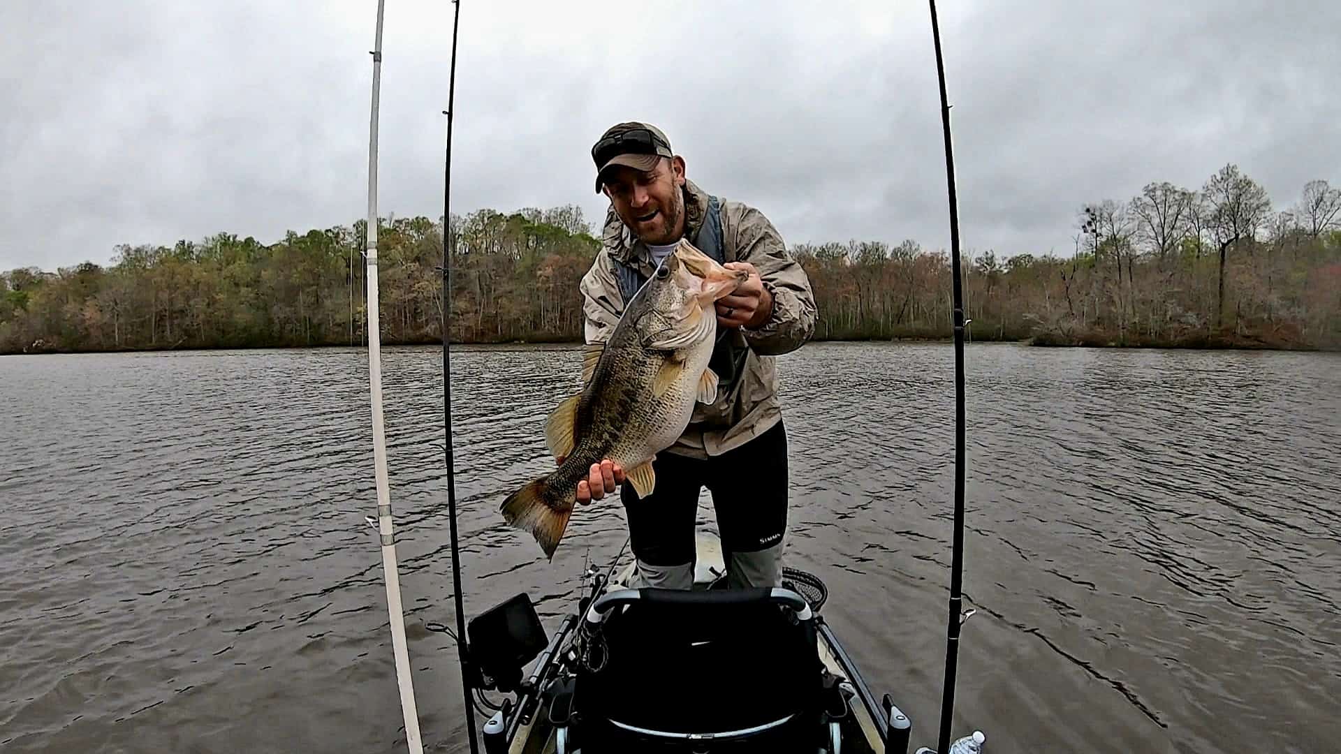 Justin Patrick holding a large mouth bass he caught on his kayak