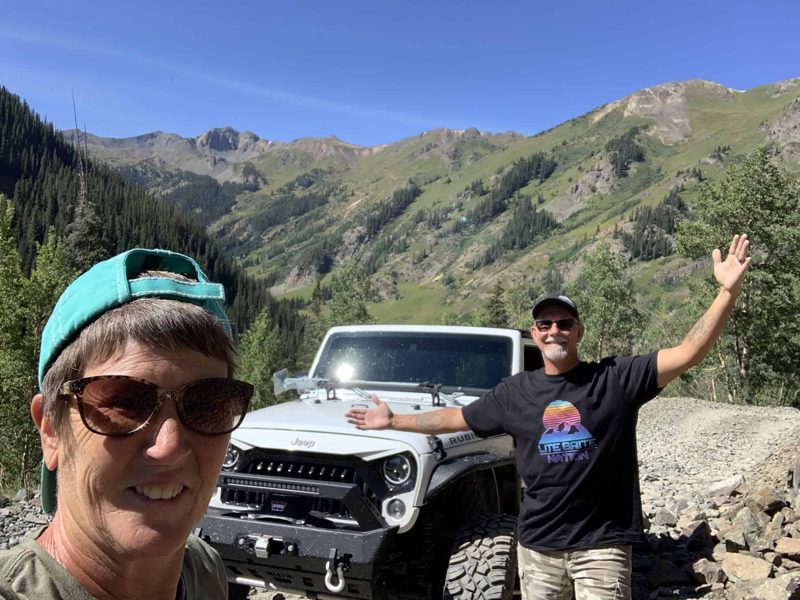 Lance and Flo Wende posing with their Jeep Rubicon in the mountains