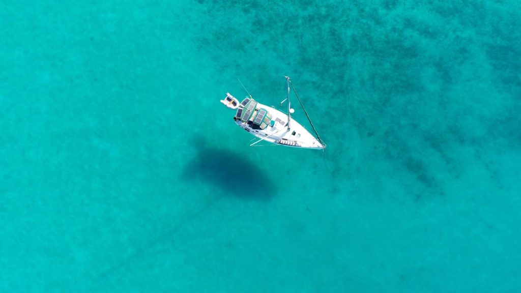 aerial shot of a sailboat in tropical water