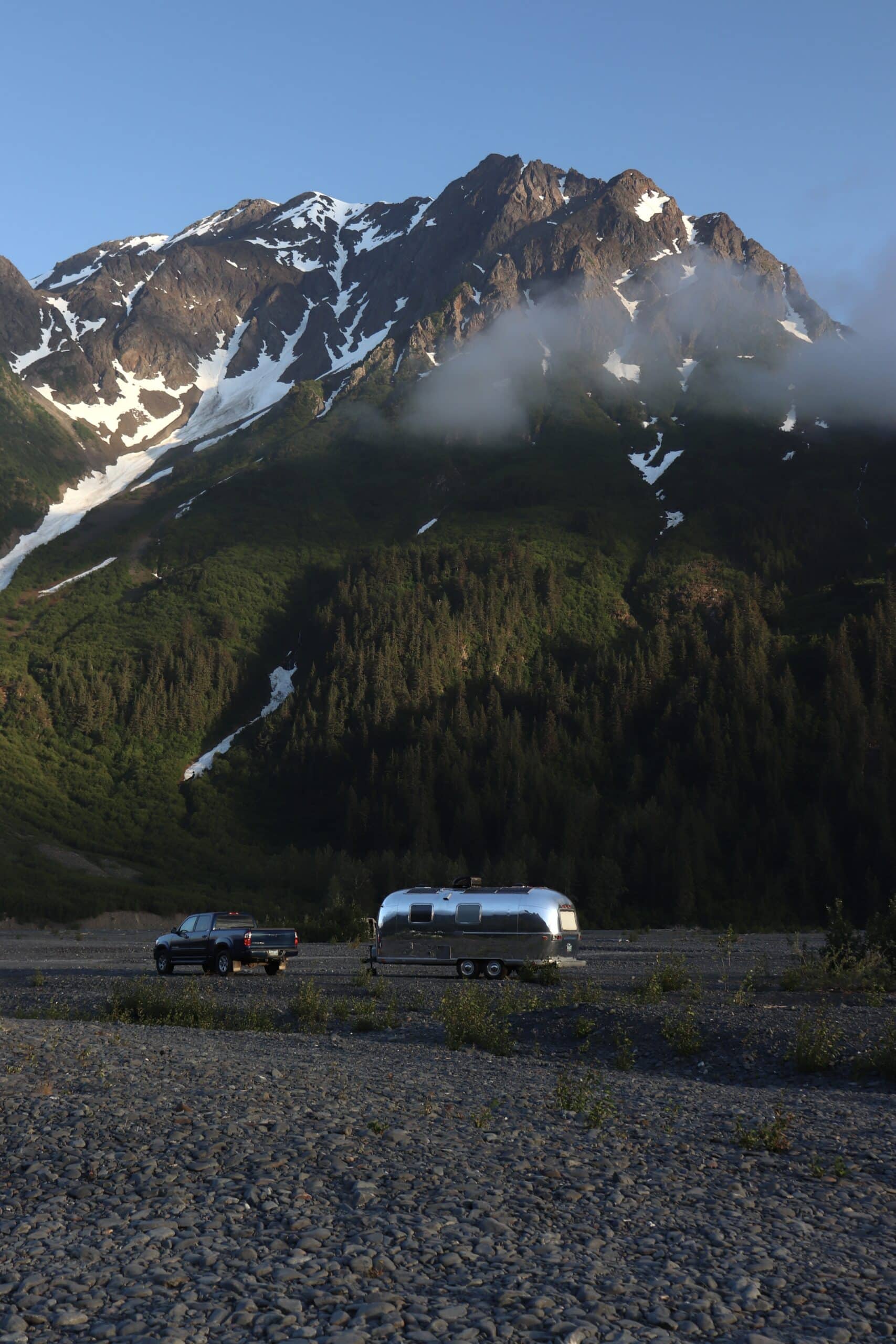 Slow Car Fast Home's Airstream Surrounded by Mountains in Alaska