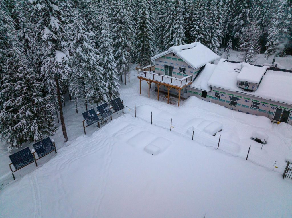 off grid house covered in snow