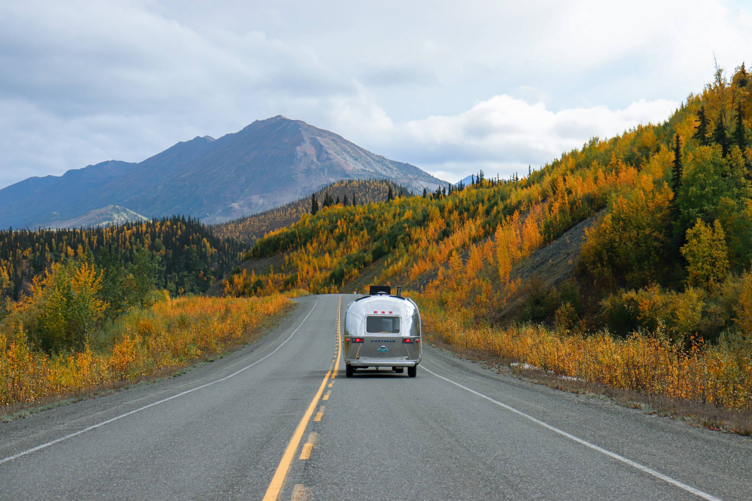 Slow Car Fast Home's Airstream in Yukon, Canada Driving Down the Highway