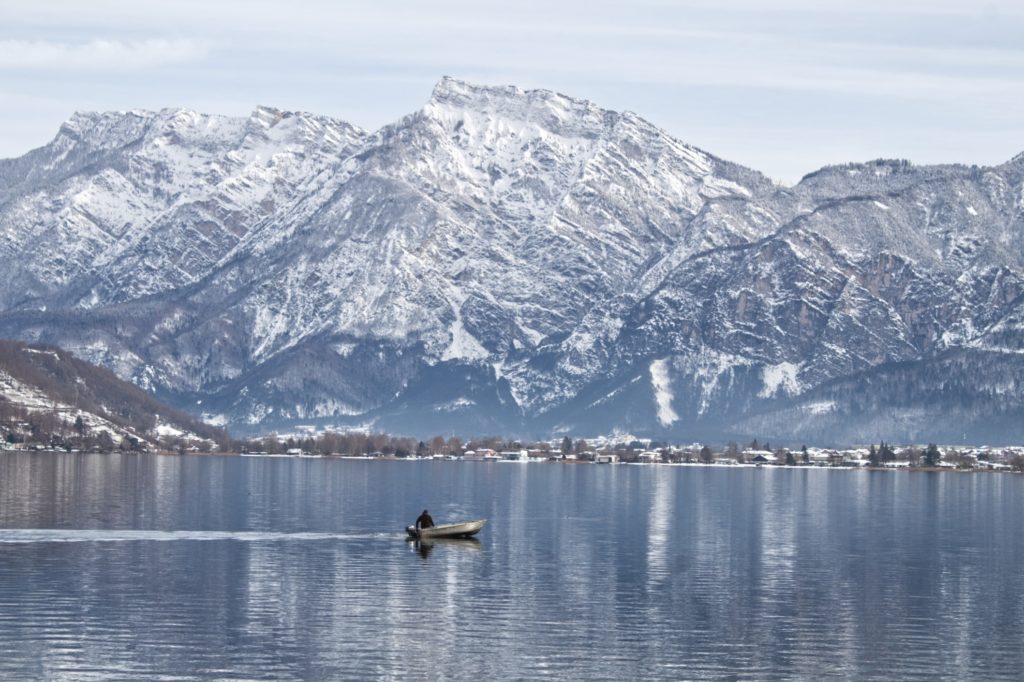 Boat on open water with large snowy mountains in the back