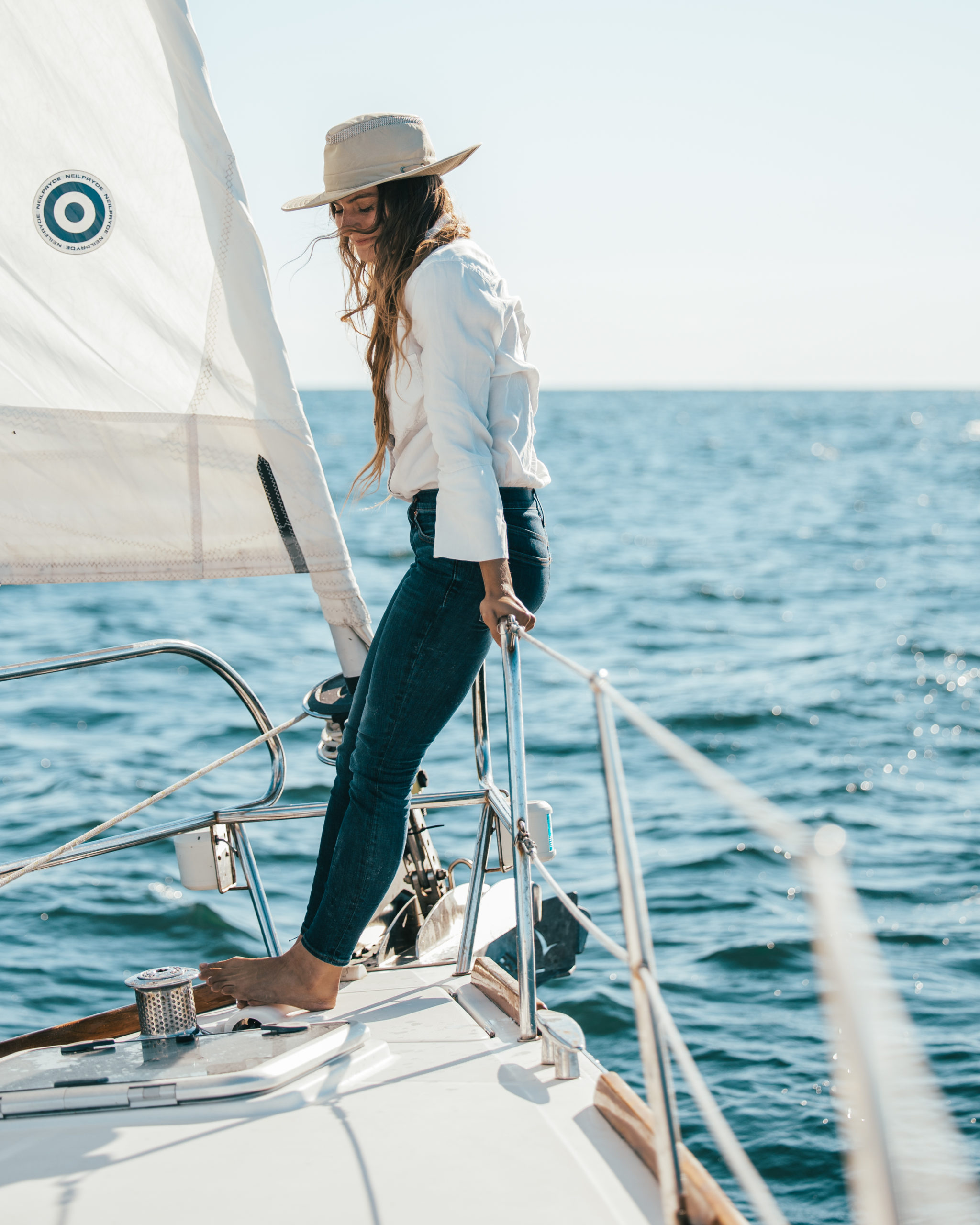 Jade Evans standing on the front of her sailboat