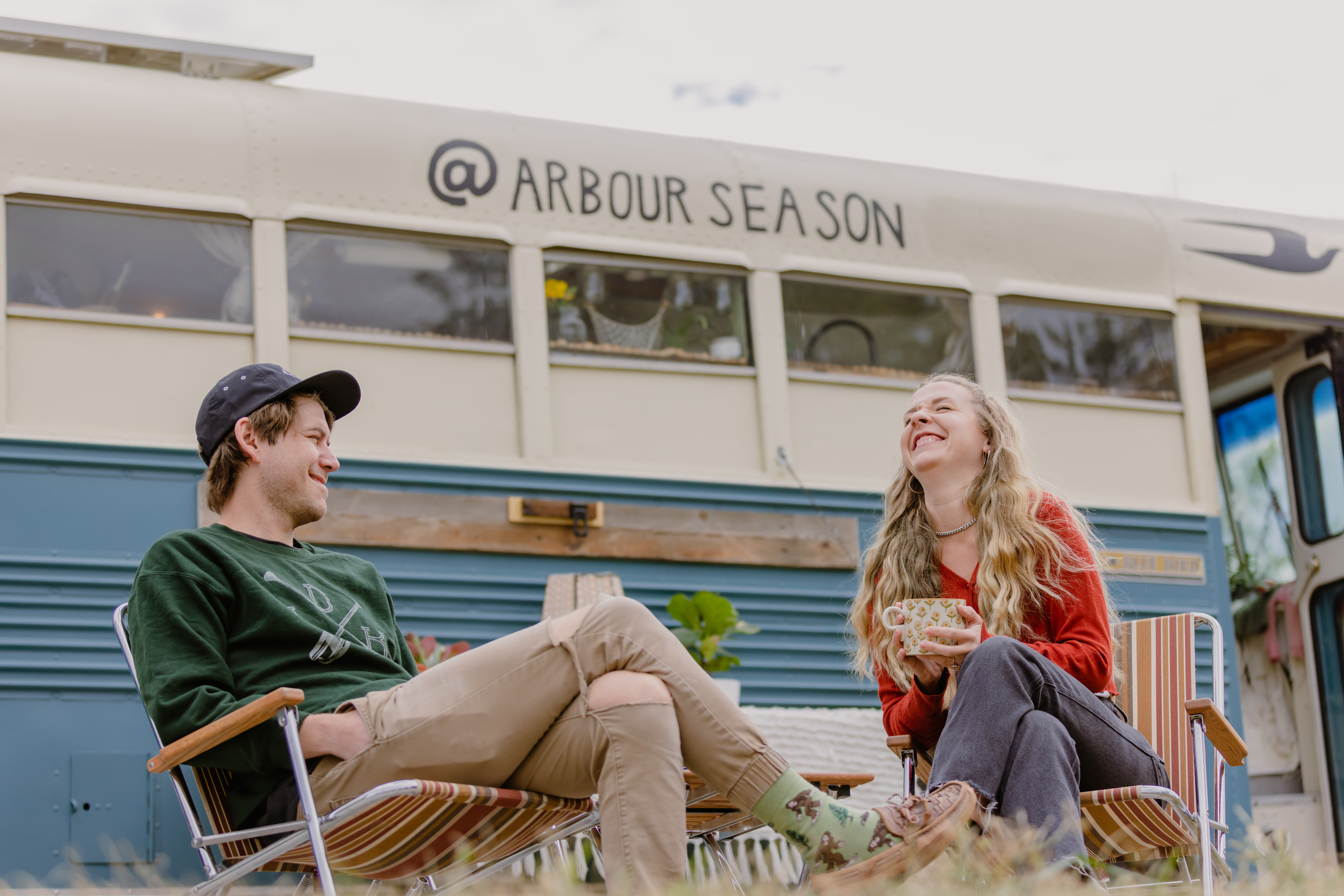 Shane and Emily From Arbour Season Having Coffee in Front of Their Converted Skoolie