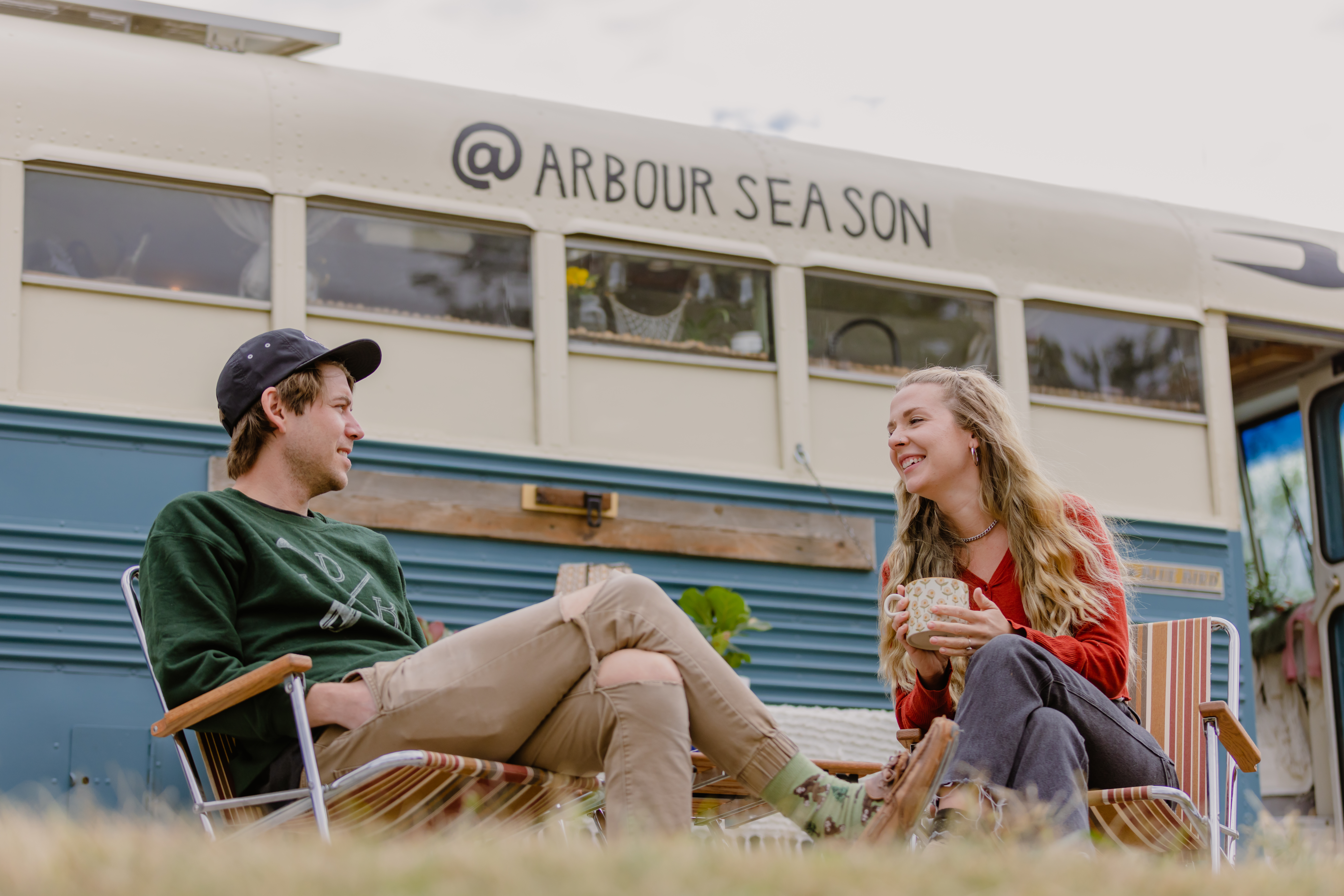 Shane and Emily From Arbour Season Having Coffee in Front of Their Converted Skoolie