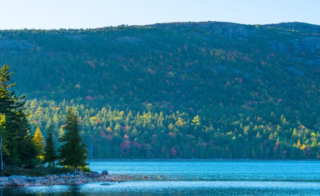 View from the shore of Jordan Pond in Acadia National Park, Maine, in Autumn during peak foliage season