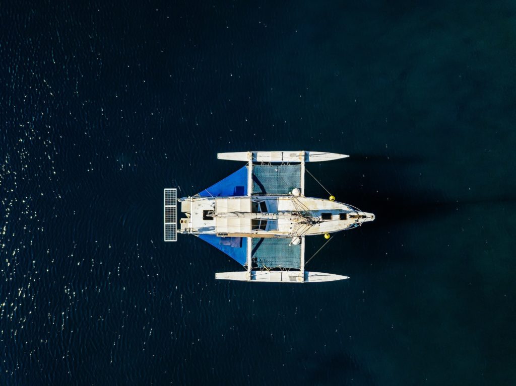 Aerial birds eye view from drone of yacht in deep blue sea