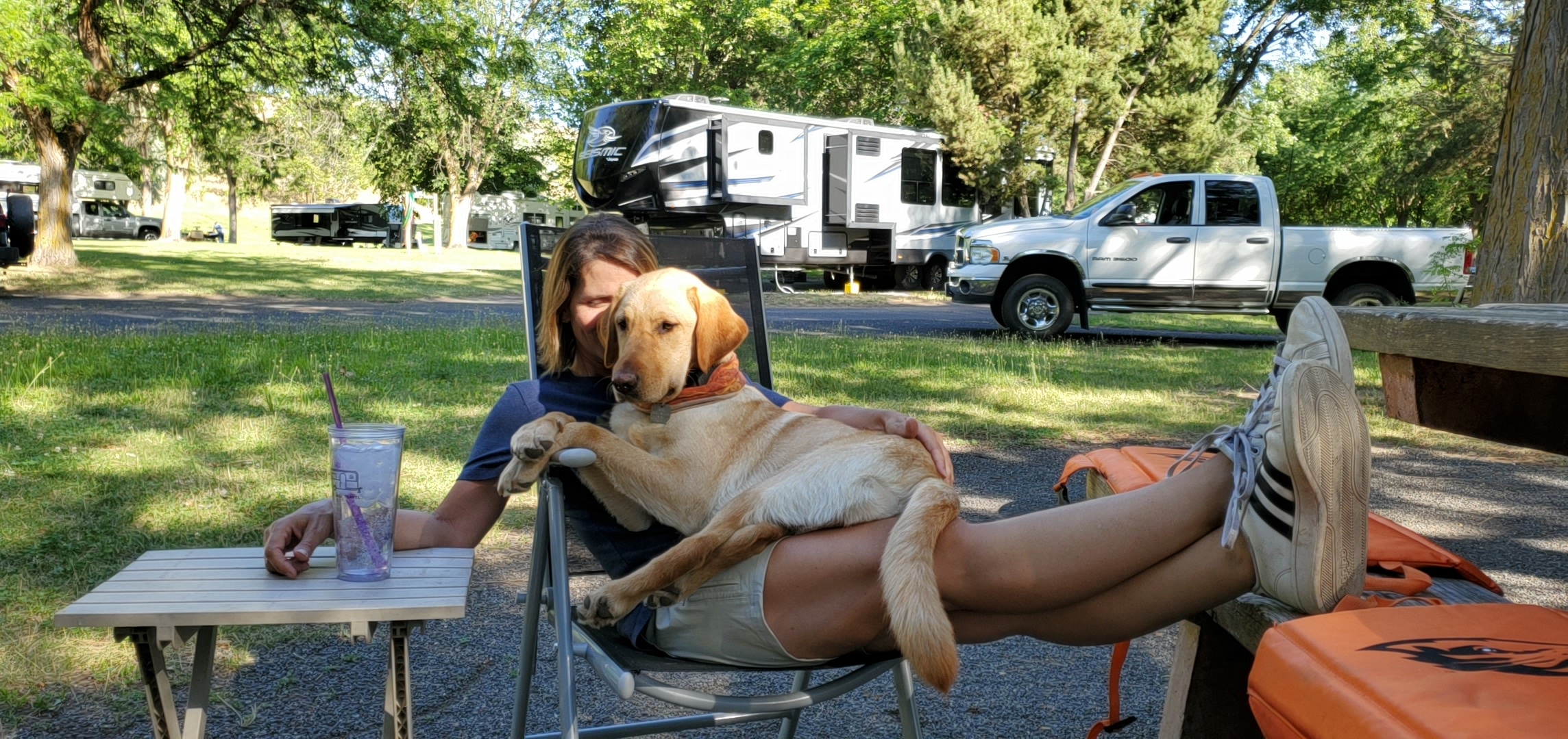 Dog sitting in a Woman's lap in a Camp Chair at an RV Park