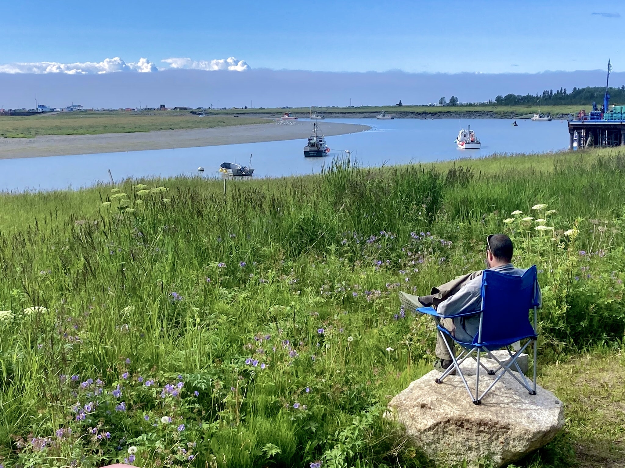 Man in a Camping Chair overlooking Boats in Alaska
