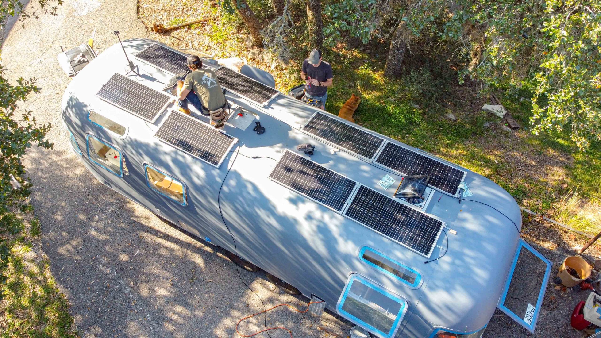 man installing solar panels on top of a trailer
