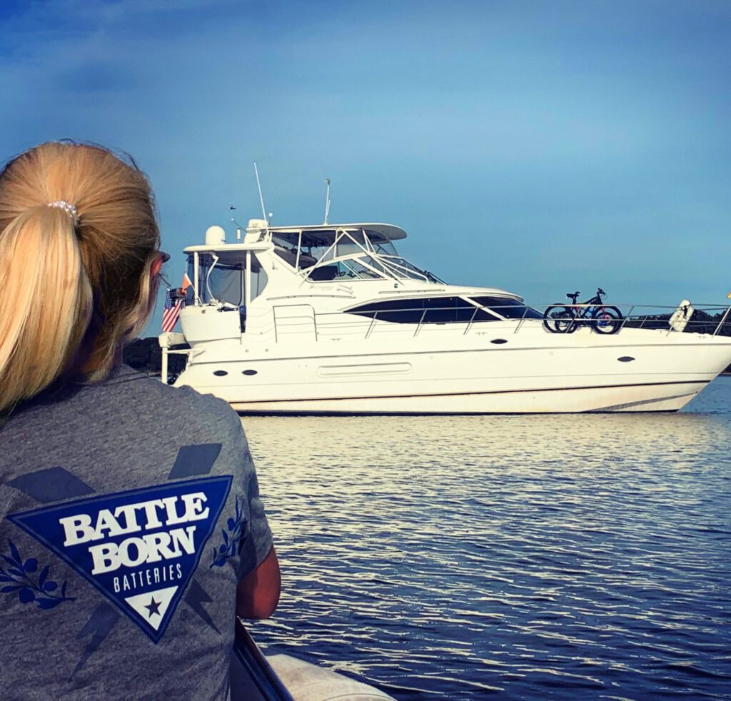 woman wearing Battle Born Batteries tshirt looking at a yacht