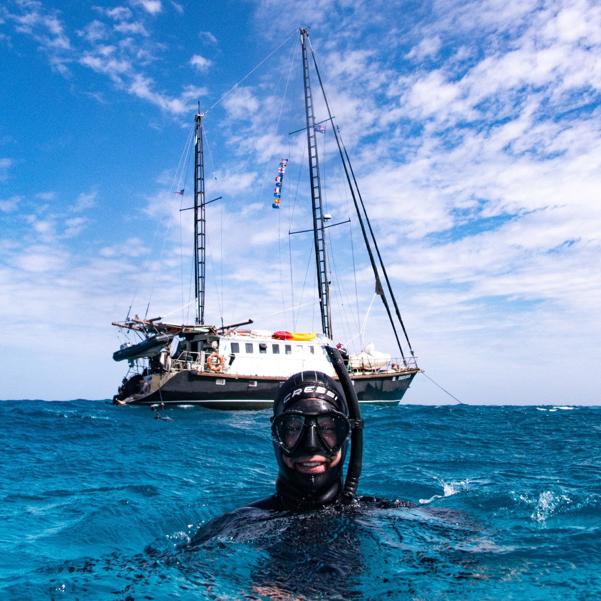 Man snorkeling in Front of a Sailboat