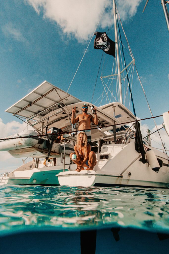 couple on sailboat with drinks in their hands