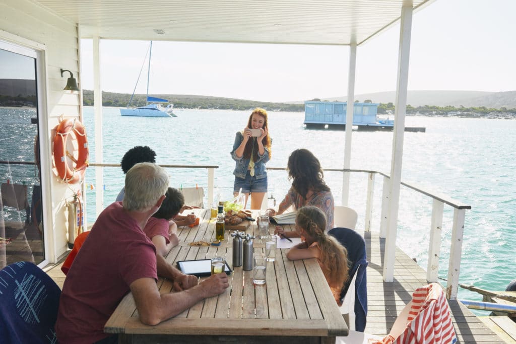 Family gathered at table on houseboat sun deck