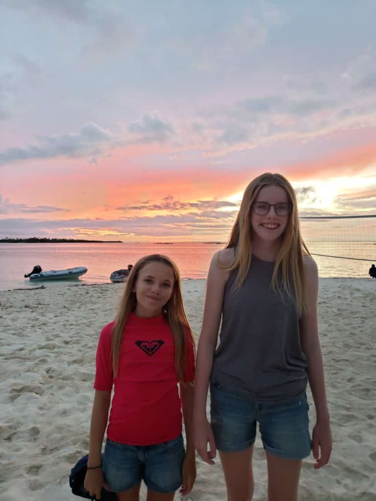 Isla and Pippa smiling on the beach during sunset