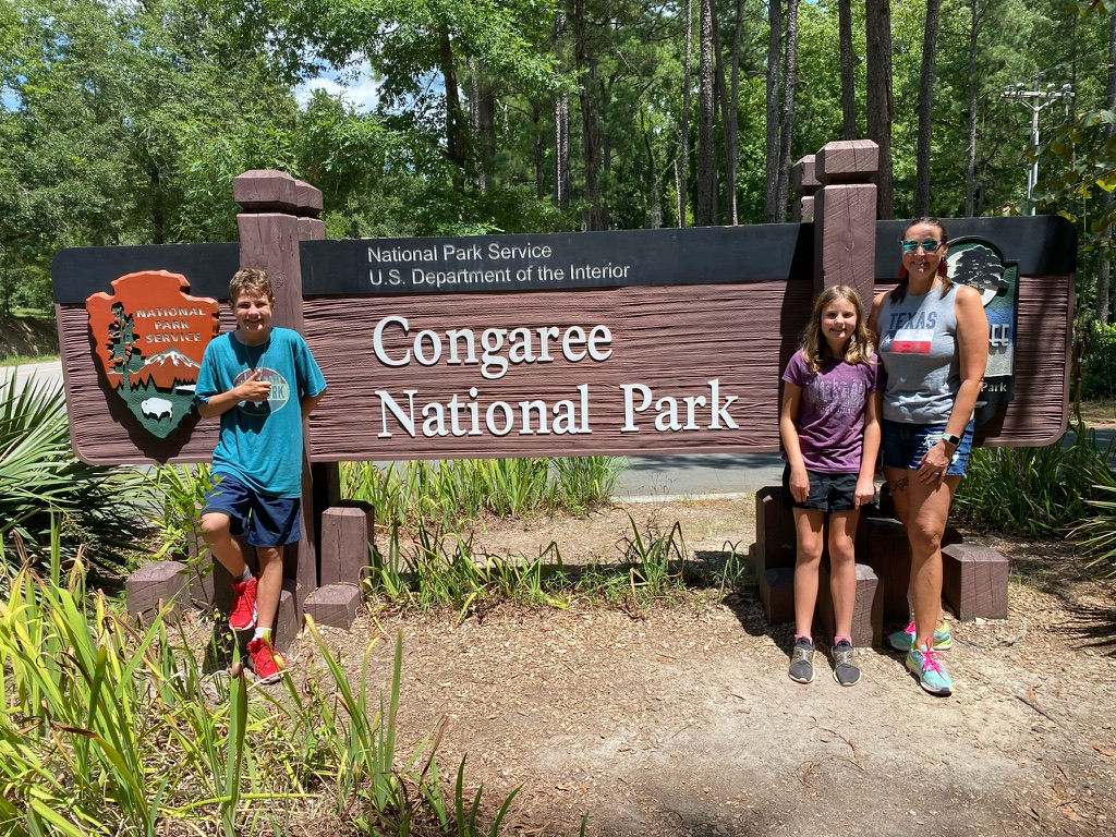 Grateful Glamper Family in front of a Congaree National Park sign