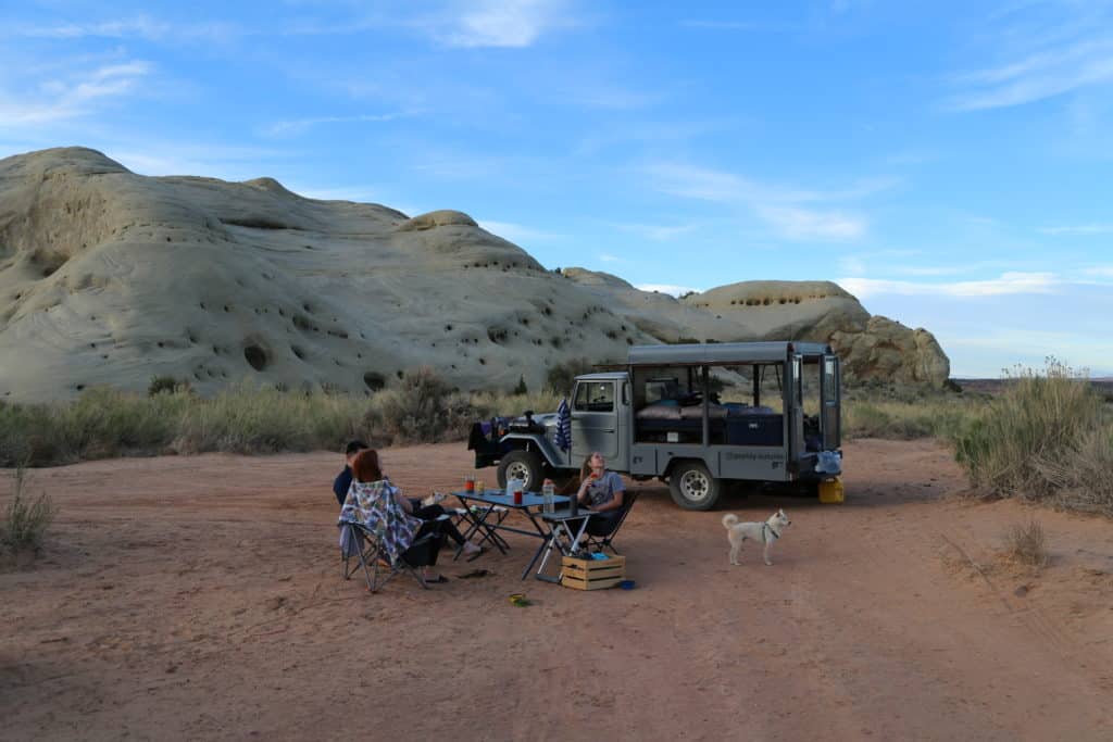 people seated at table at overland campsite